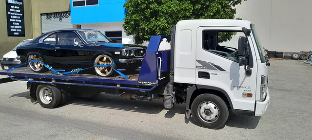 Black Mustang with gold rims secured on the Advanced Blue Towing tilt tray