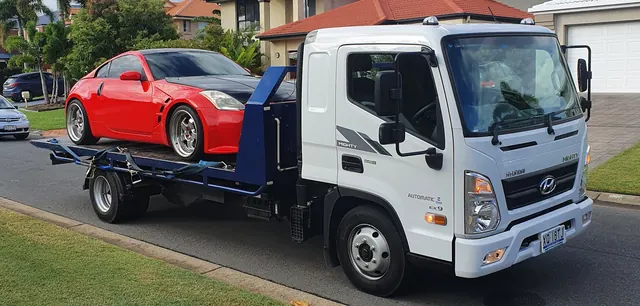 A red Nissan 350Z carried on the Advanced Blue Towing tilt tray